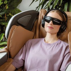 Collaboratrice se relaxant dans un fauteuil massant BrainLight avec casque audio et masque visuel